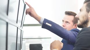 bras pointant sur les panneaux d'ordinateur
