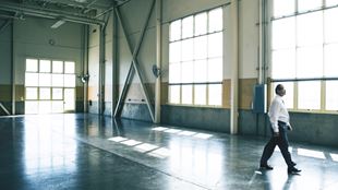 man walking in large empty garage