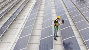 man checking solar panels