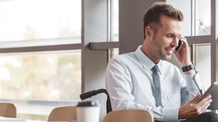 man on phone sitting at table