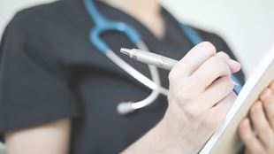 Closeup of health professional writing a note