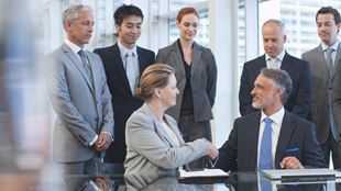 group of business people signing a deal