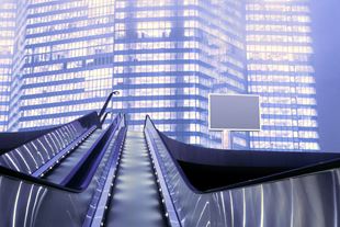 Low angle shot of escalators in front of sky scrapers