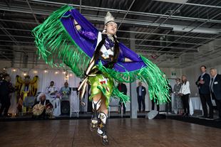 Young First Nations woman in traditional attire doing dance for reconciliation