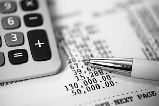 Close-up of pen and calculator on financial documents
