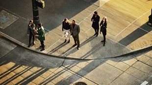 Wide shot overhead view of business people waiting to cross street