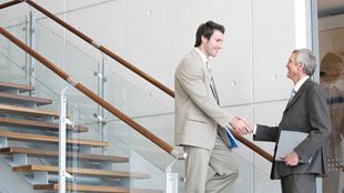 two men shaking hands on staircase