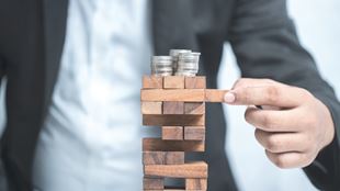 homme d'affaires jouant Jenga avec de l'argent sur le jeu