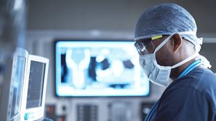 doctor looking at test results in scrubs